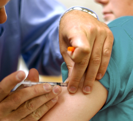 Closeup of a youth getting a shot in the arm
